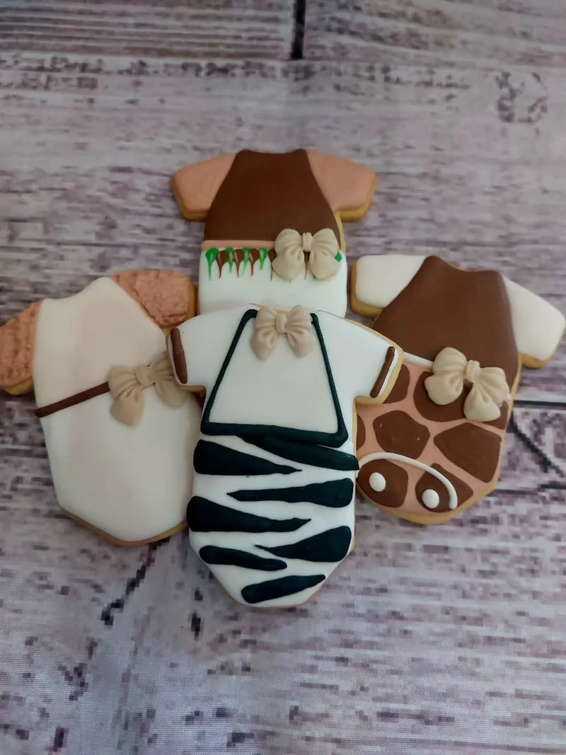Safari-themed baby onesie cookies with zebra and giraffe prints for baby showers