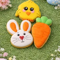 Adorable set of three mini 6cm Easter iced cookies featuring chick, bunny face, and carrot on spring grass