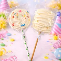 Large vanilla meringue on a stick, beautifully decorated with colorful sprinkles